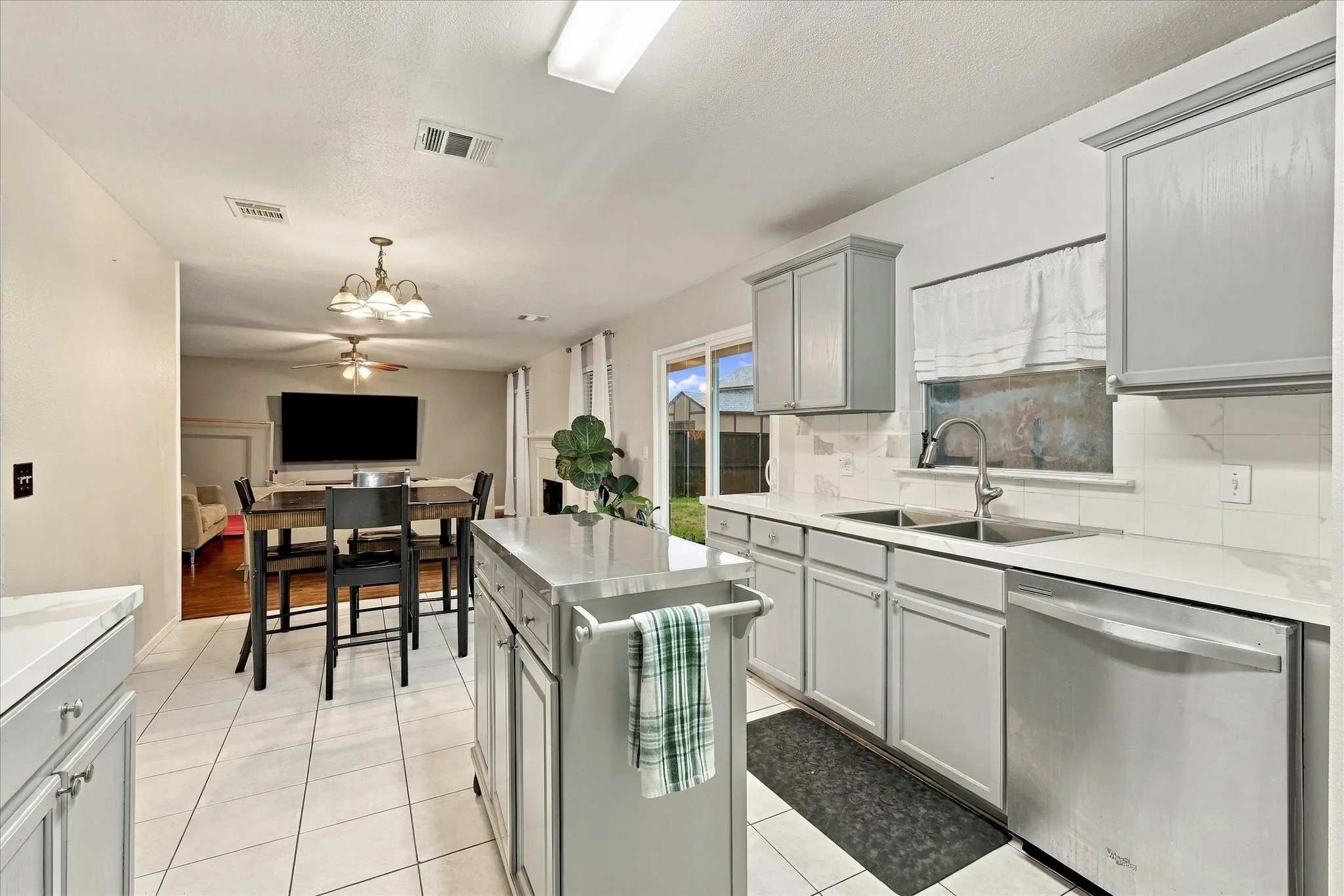 Kitchen featuring stainless steel appliances, light gray cabinetry, white countertops, and a tile backsplash
