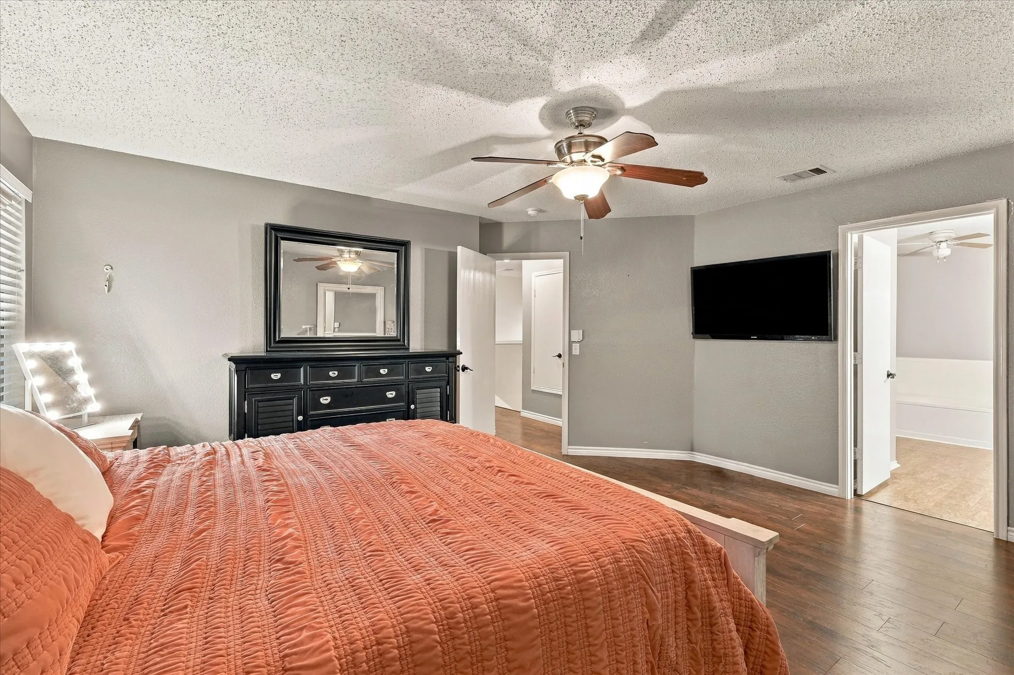 Hardwood-finish flooring, ceiling fan with integrated lighting, window with blinds, and neutral-toned walls