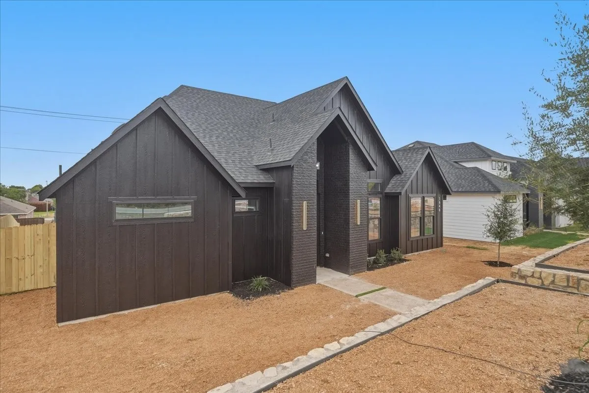 Contemporary exterior featuring dark vertical siding and a prominent entryway