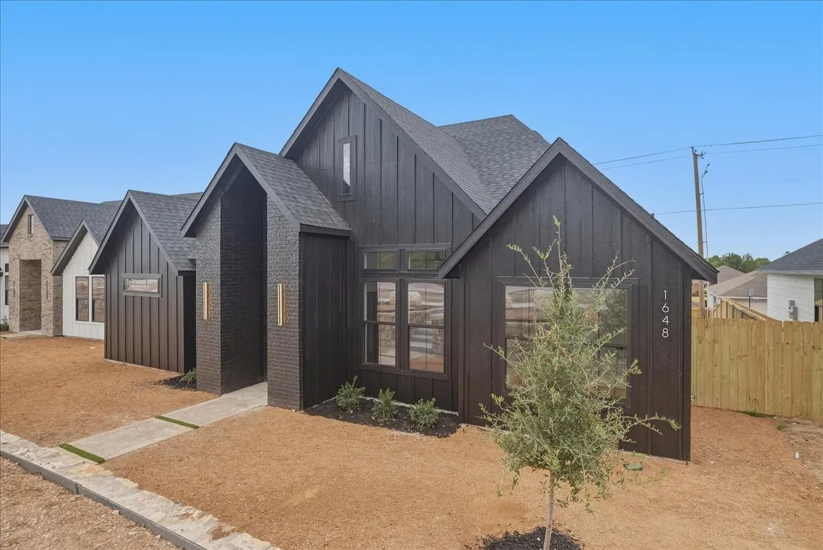 Contemporary exterior featuring board and batten siding and brick accents