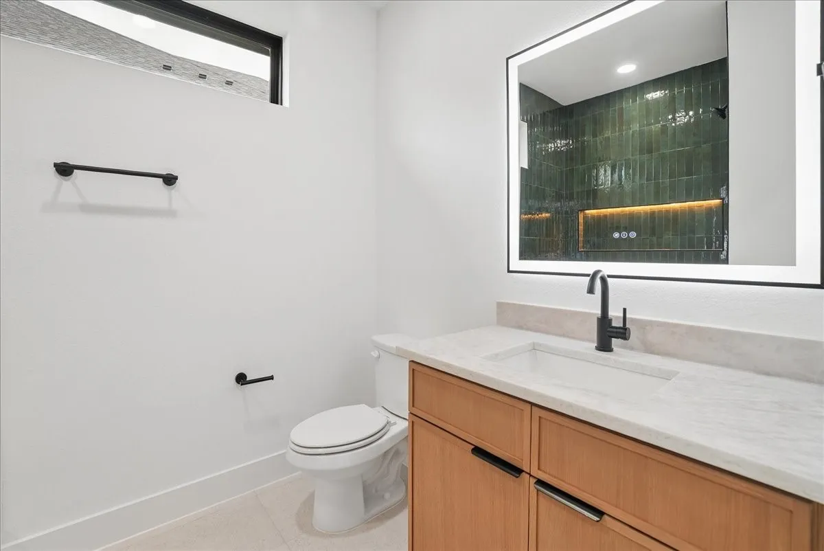 Modern vanity with wood-finish cabinetry, integrated sink, and stone countertop