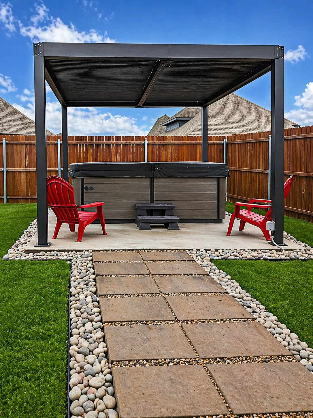 Backyard featuring a hot tub under a contemporary black pergola, bordered by a concrete patio