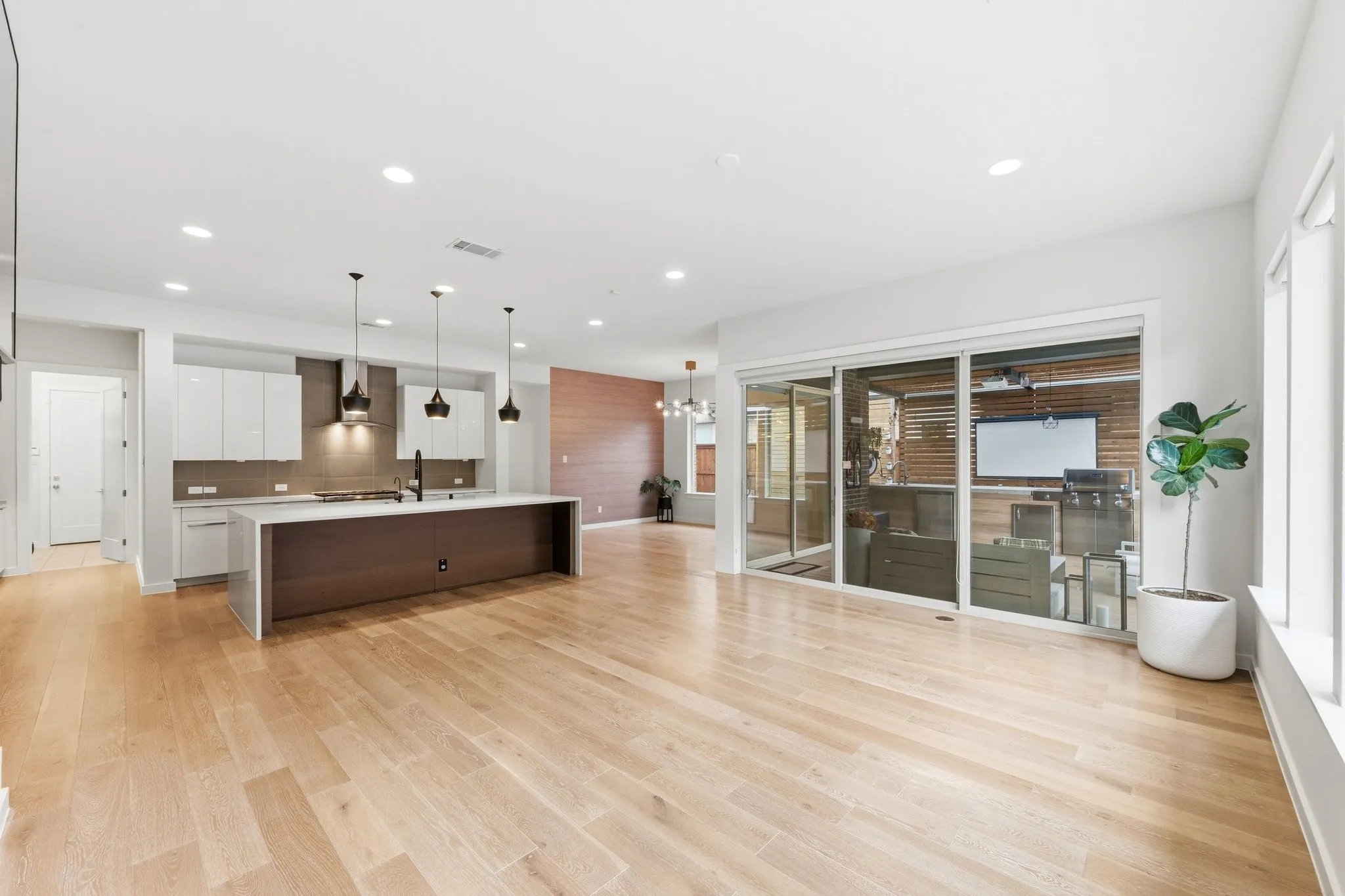 Gourmet chef's kitchen anchored by an oversized quartz waterfall island and modern aesthetic.