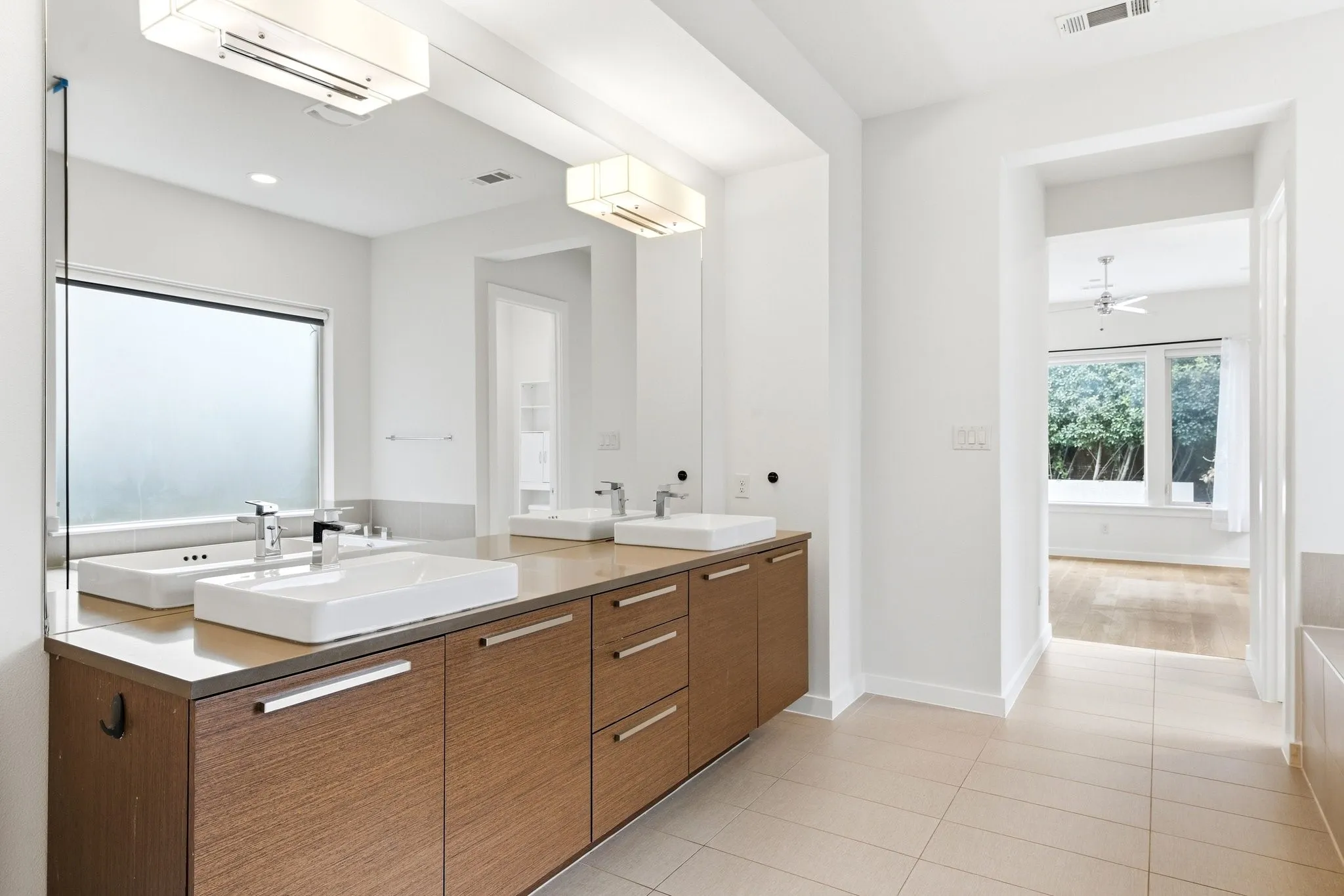 Primary bathroom highlighting luxury finishes, crisp tile work, and abundant natural light.