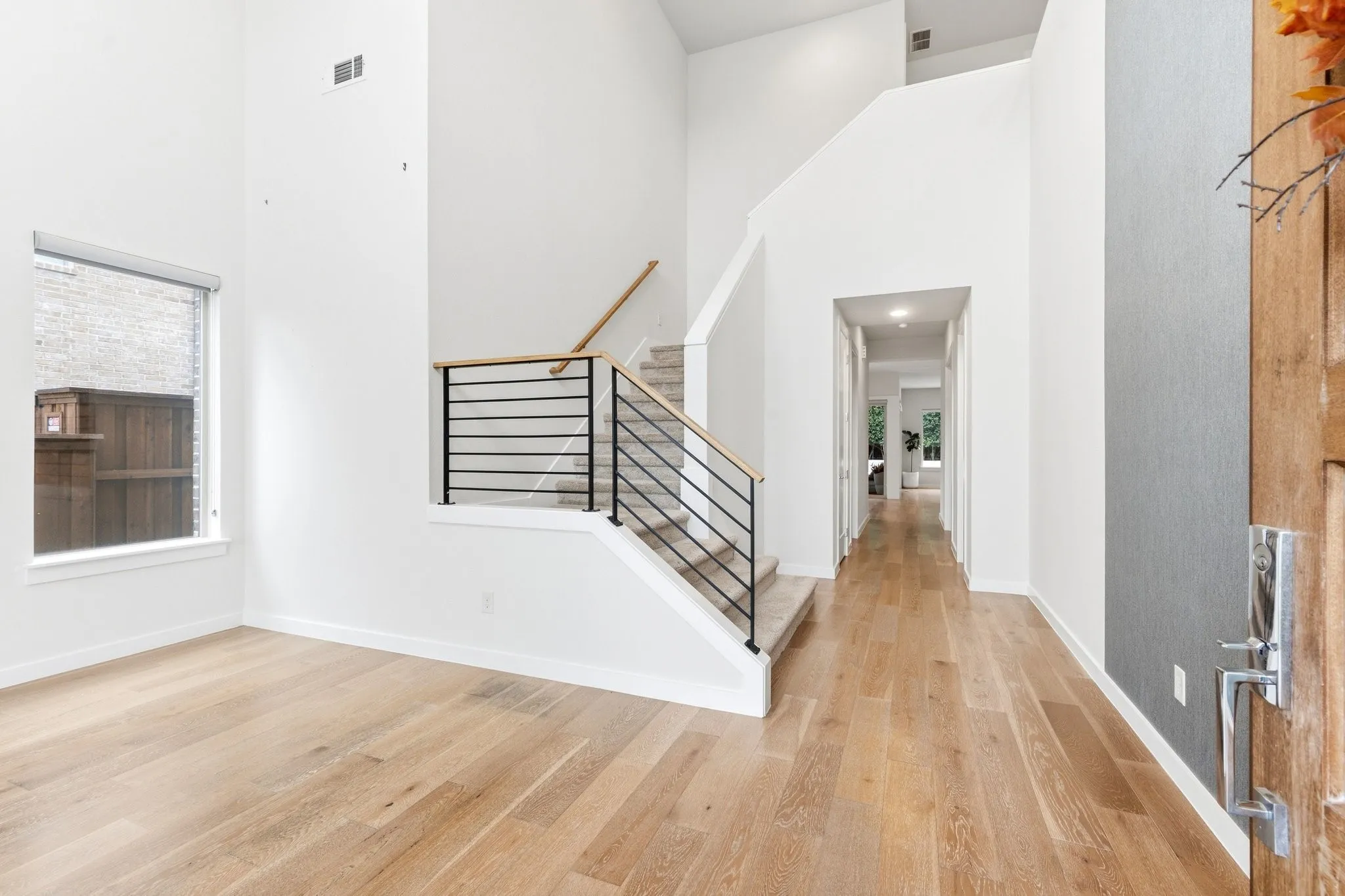 Dramatic entry hall with soaring ceilings, clean lines, and continuous luxury flooring.