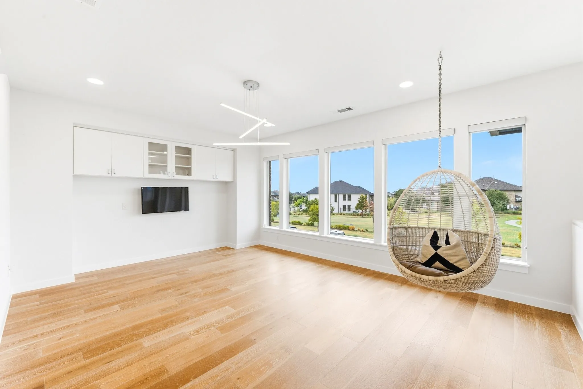 Spacious upstairs game room with expansive windows framing panoramic park views.