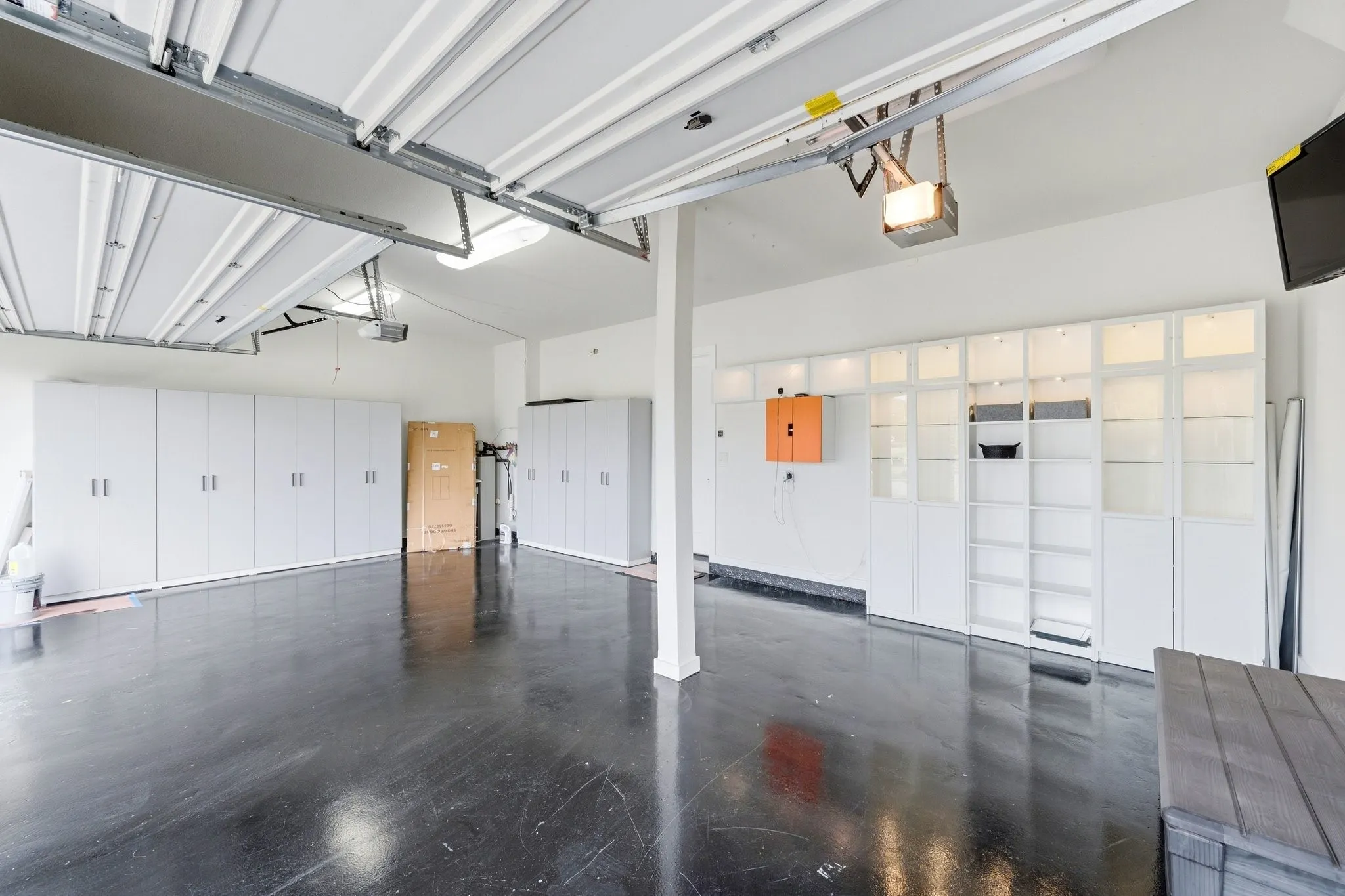 Oversized pristine 3-car garage with epoxy flooring and ample storage space.