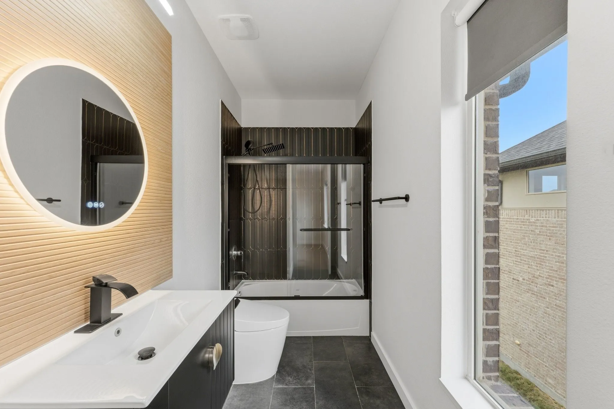 Remodeled designer bath featuring a back-lit LED mirror and custom wood slat accent wall.