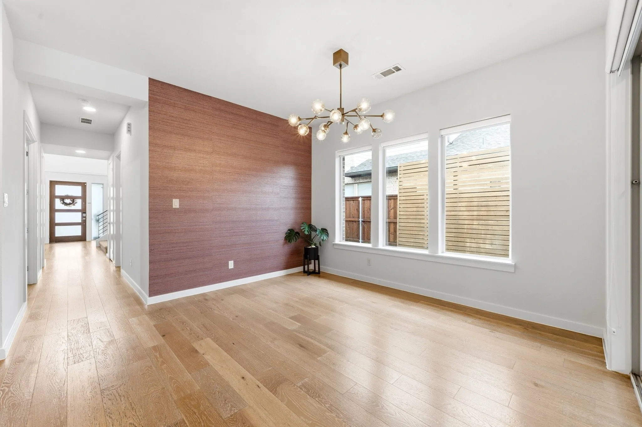 Expansive dining room showcasing rich hardwoods and grand wall of glass doors.