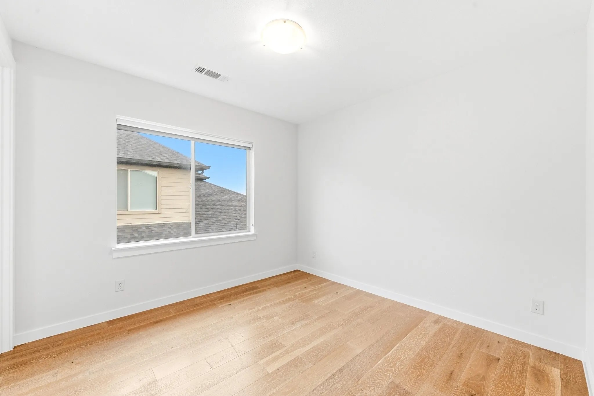 Generously sized upstairs bedroom with neutral finishes and great natural light.