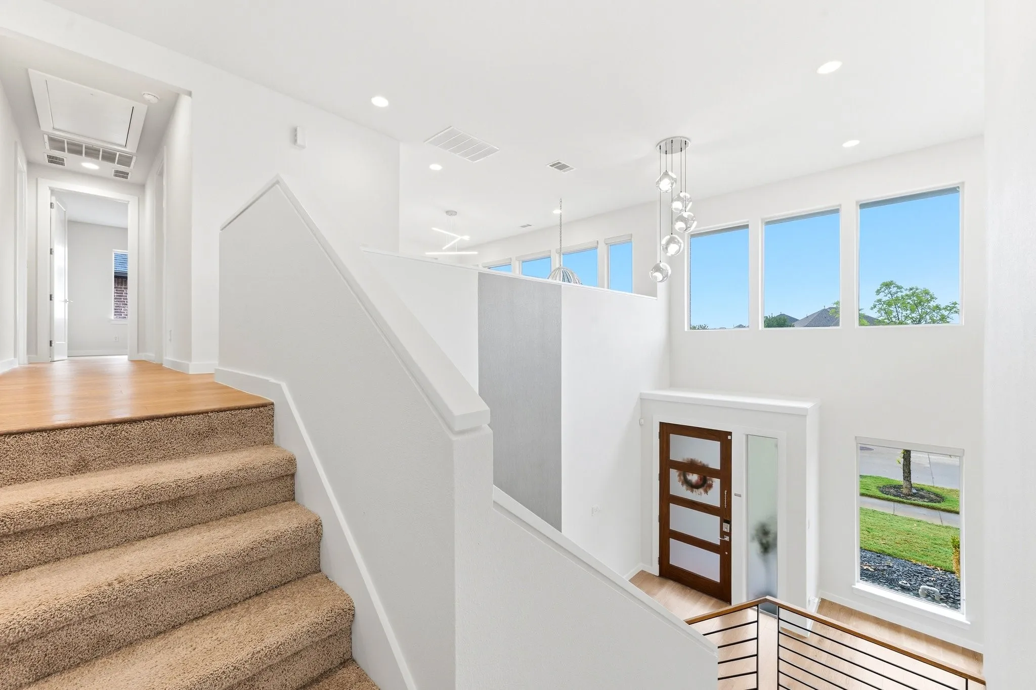 Bright upper-level landing overlooking the foyer and main living space below.