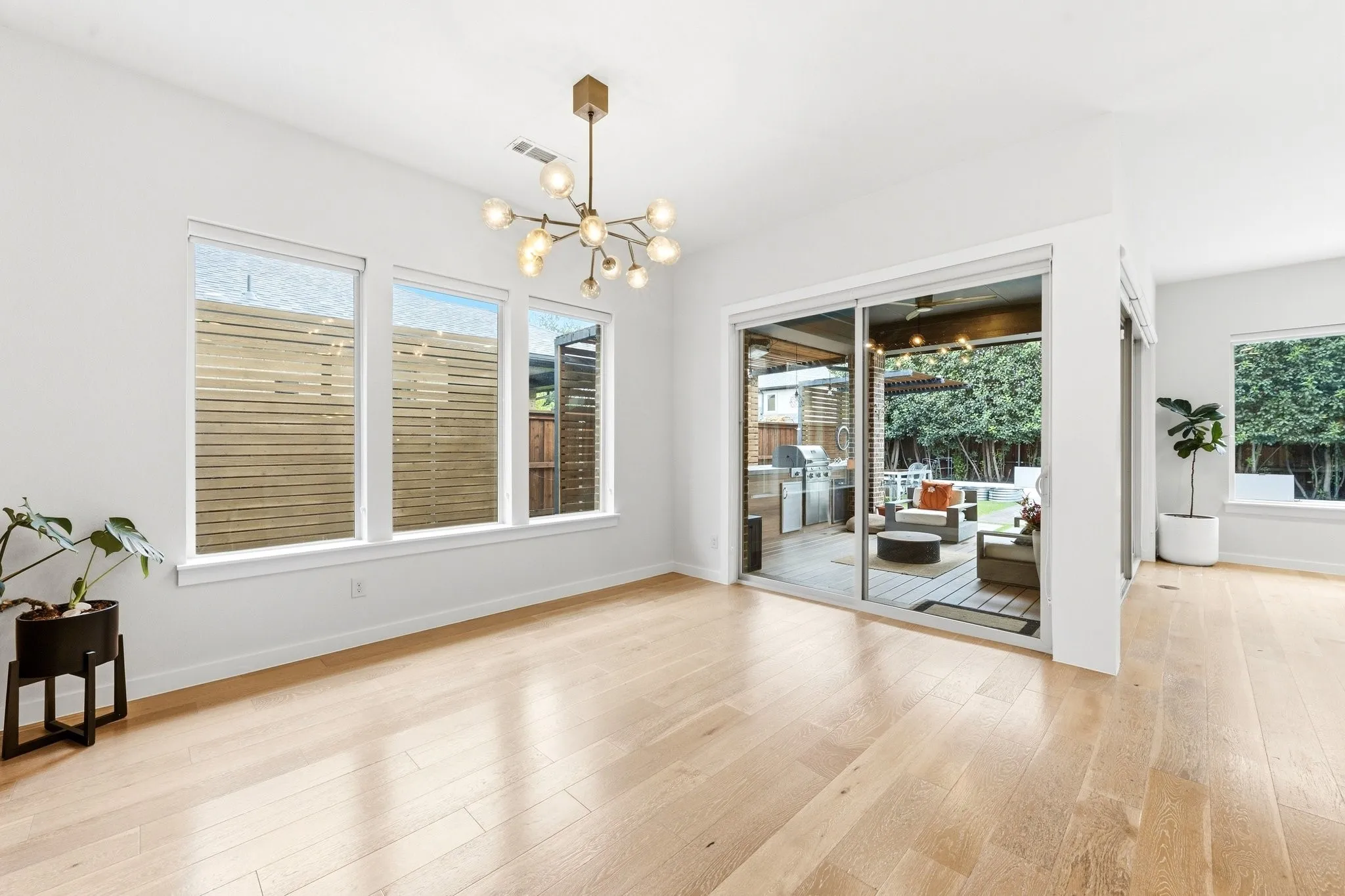 Sun-drenched open concept dining area highlighting soaring ceilings and architectural layout.