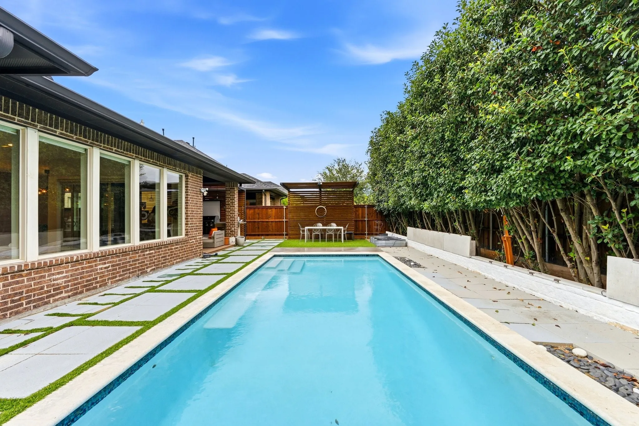 Resort-style backyard featuring a custom in-ground pool, spa, and private living fence.
