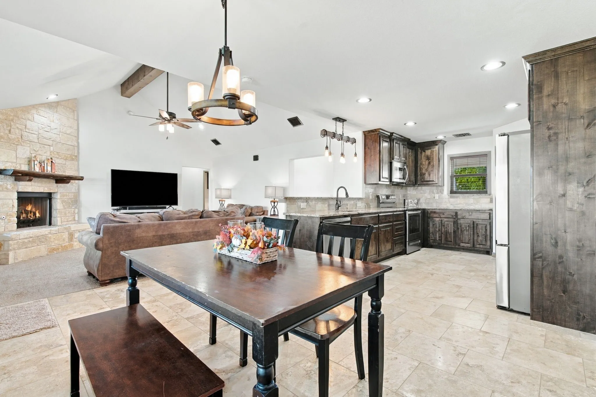 Open-concept living area with vaulted ceilings and exposed wood beams