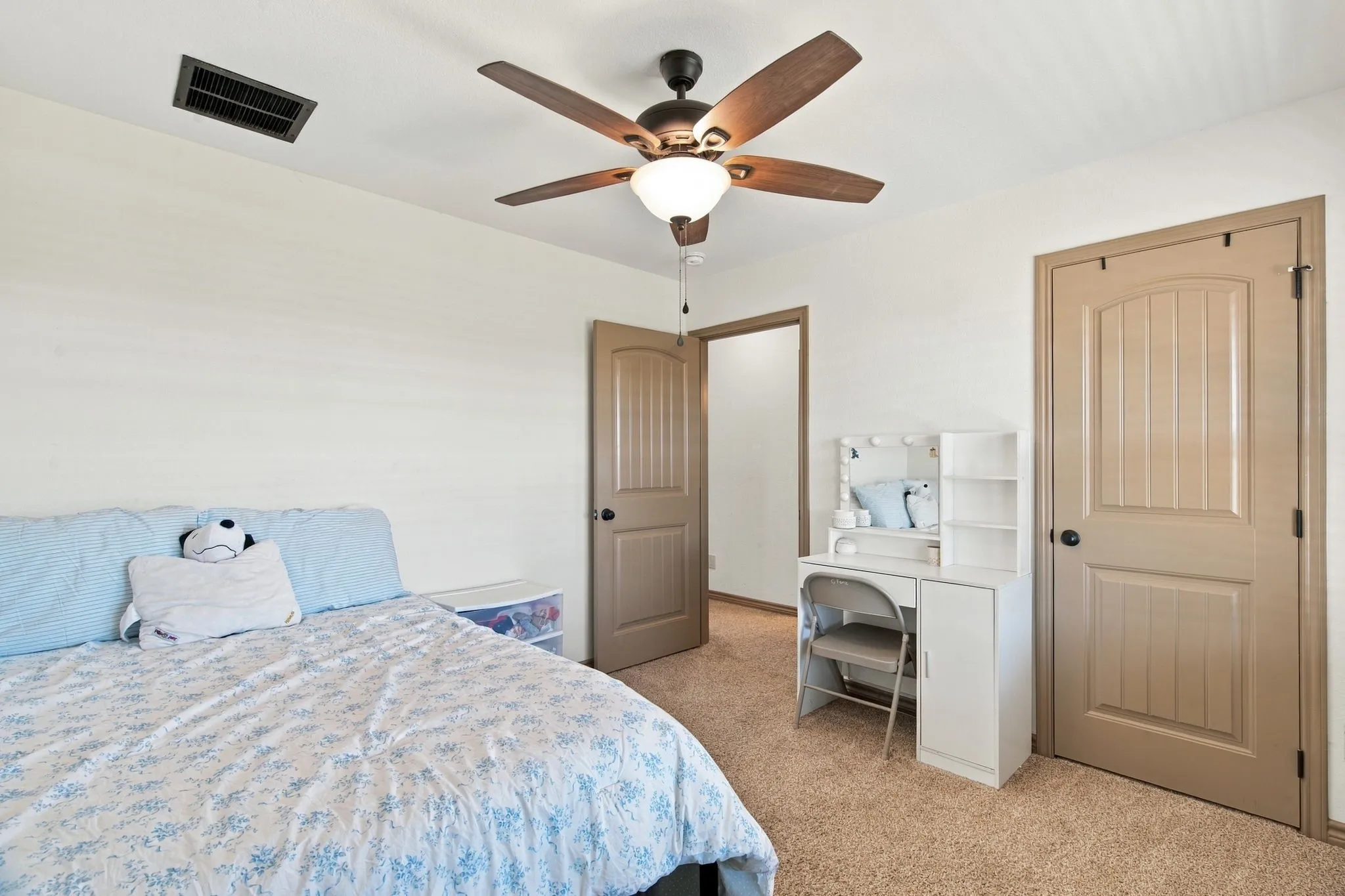 Ceiling fan with integrated lighting, wood-finish interior doors, and carpet flooring