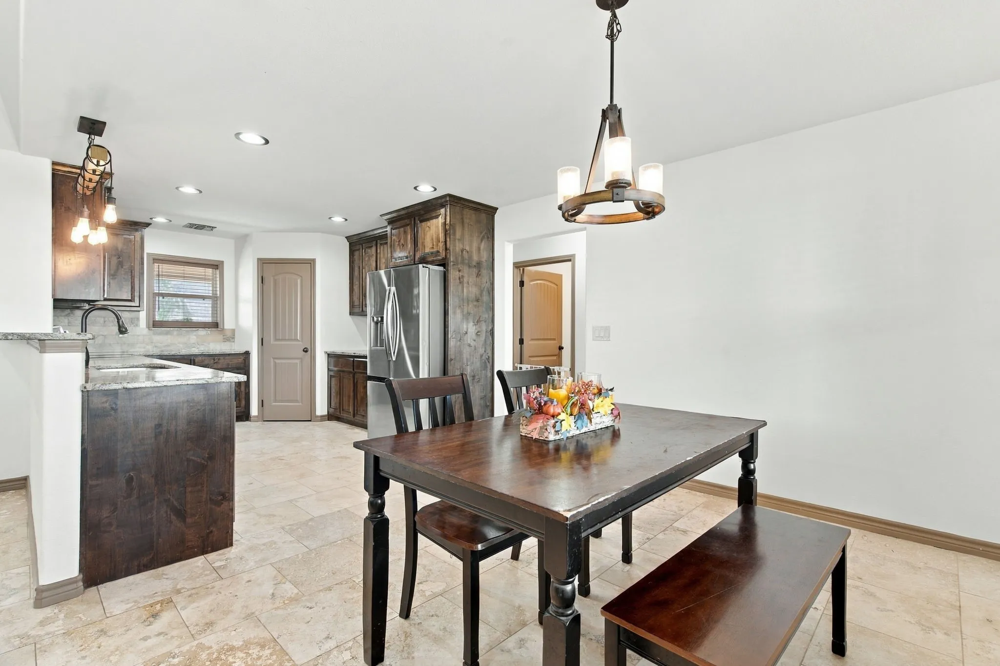 Kitchen featuring dark wood cabinetry, stainless steel refrigerator, and recessed lighting