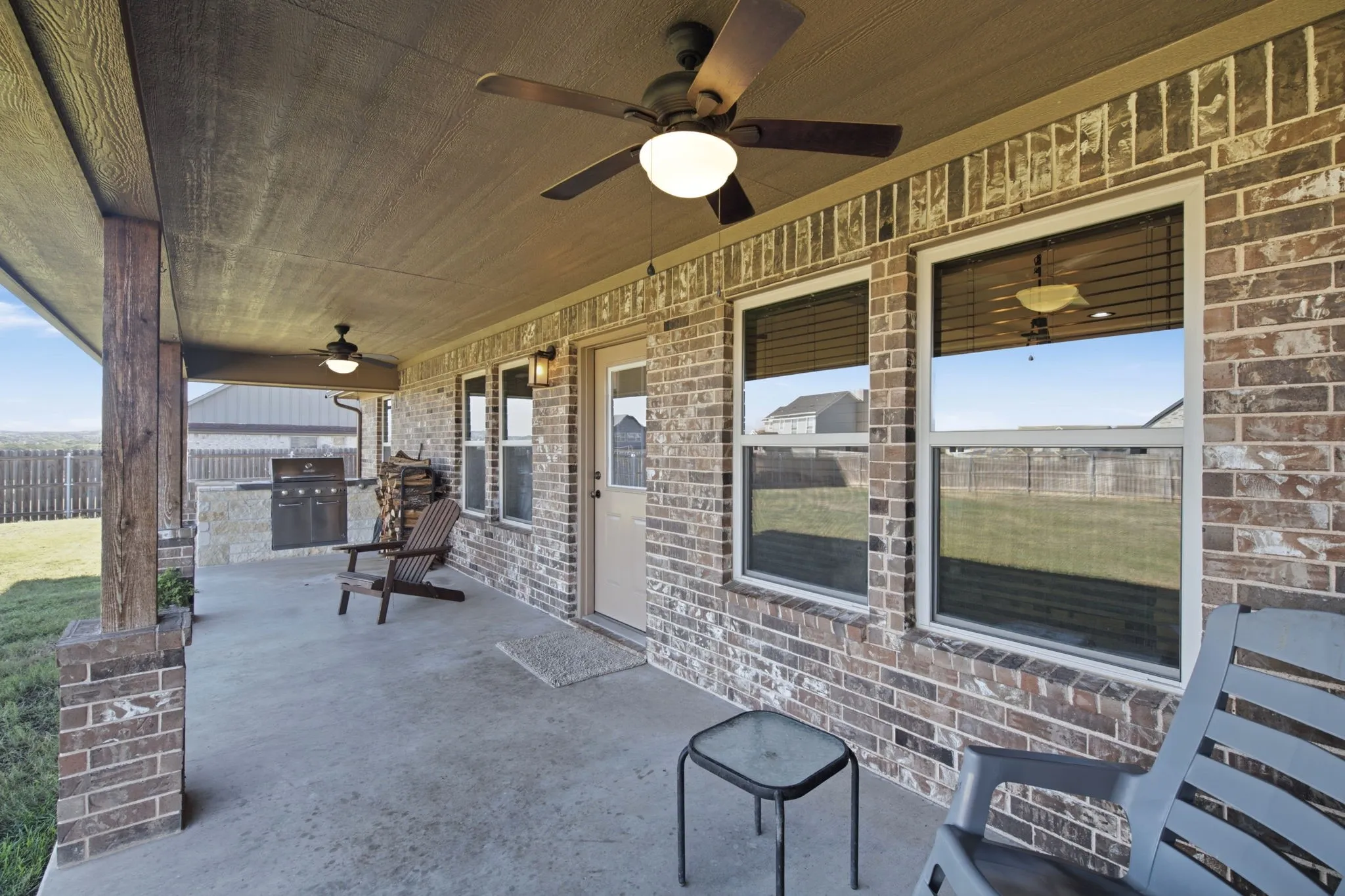 Covered patio featuring a ceiling fan, recessed lighting, and a built-in outdoor grill station with brick accents