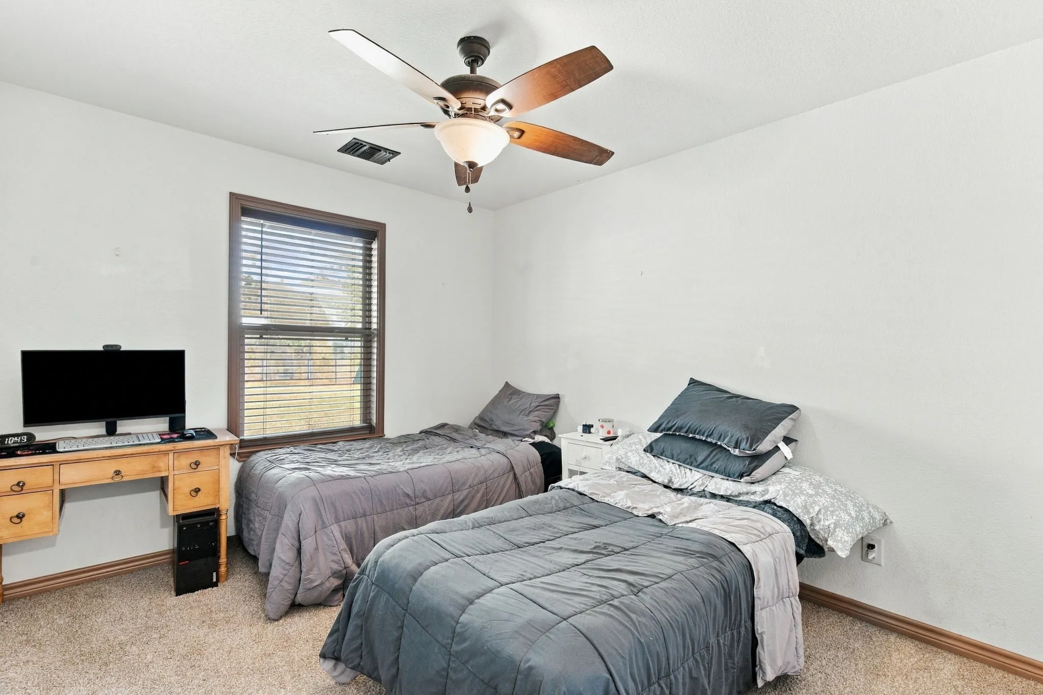 Carpeted flooring, a window with blinds, and a ceiling fan with integrated lighting