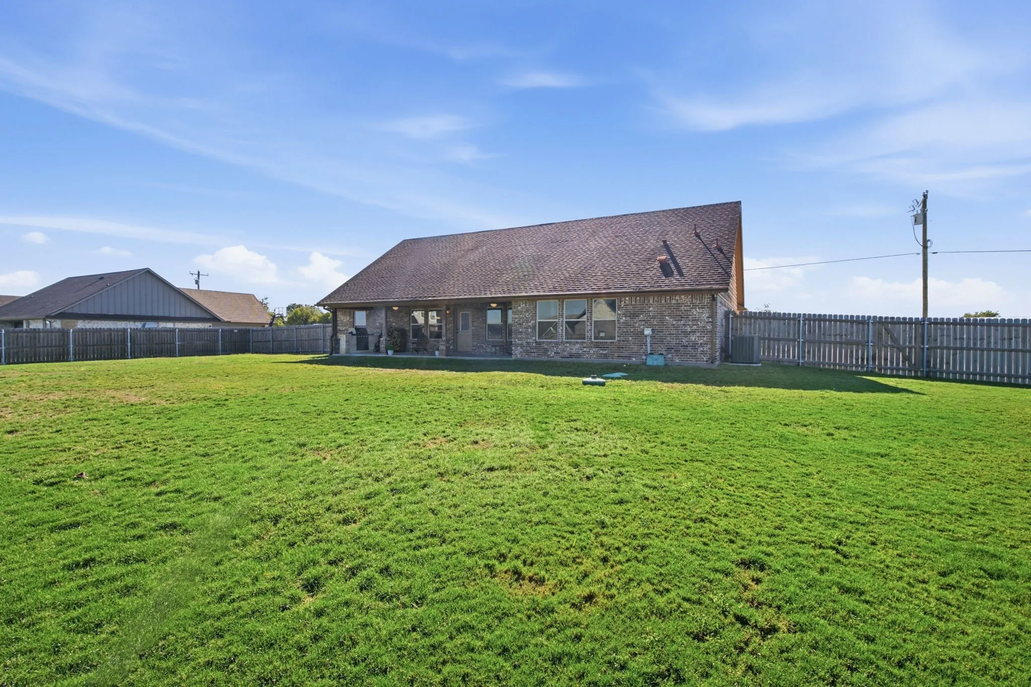 Expansive grassy yard enclosed by a wood picket fence