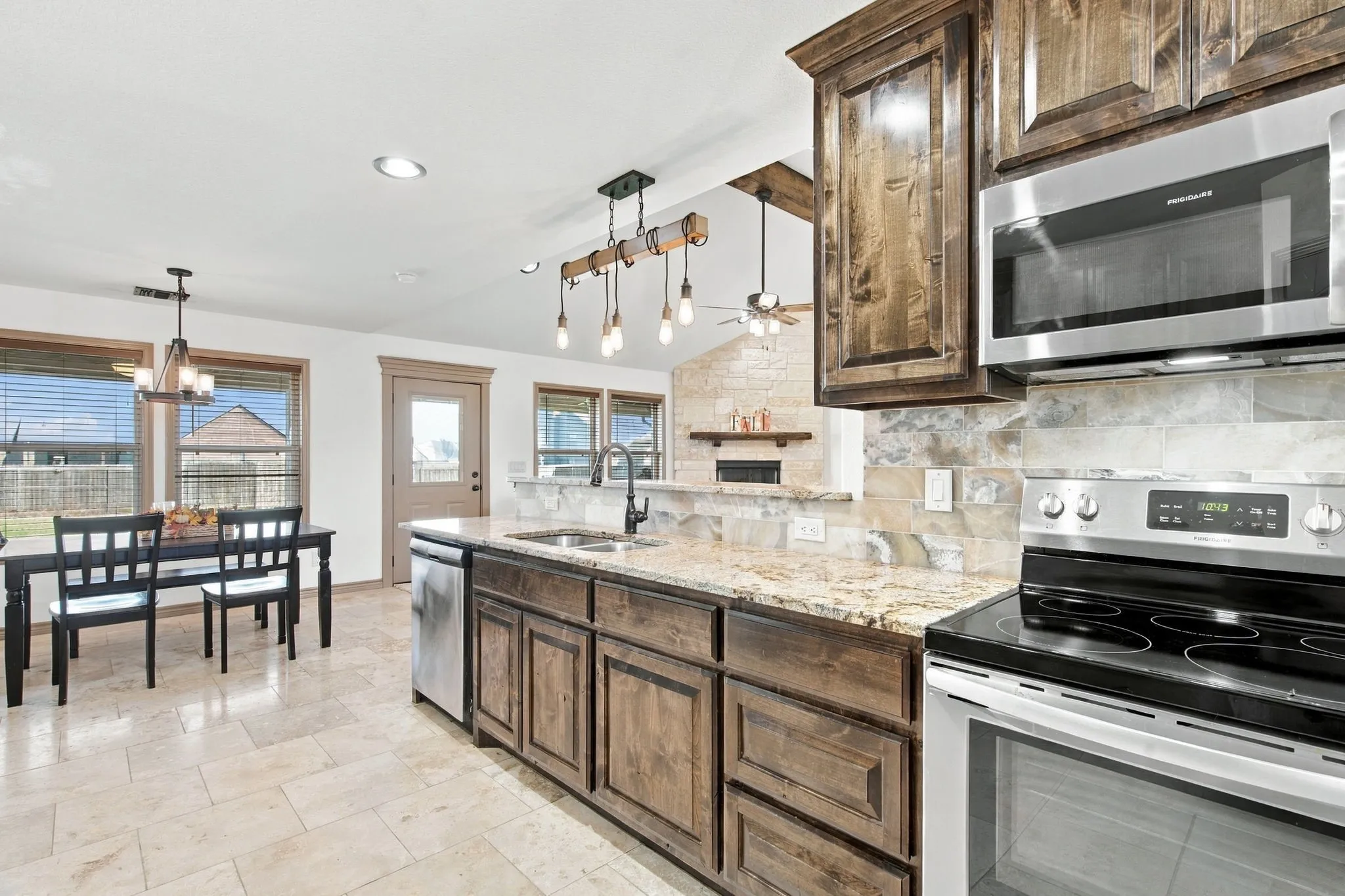 Kitchen featuring wood cabinetry, granite countertops, tile flooring, stainless steel appliances, and a stone backsplash