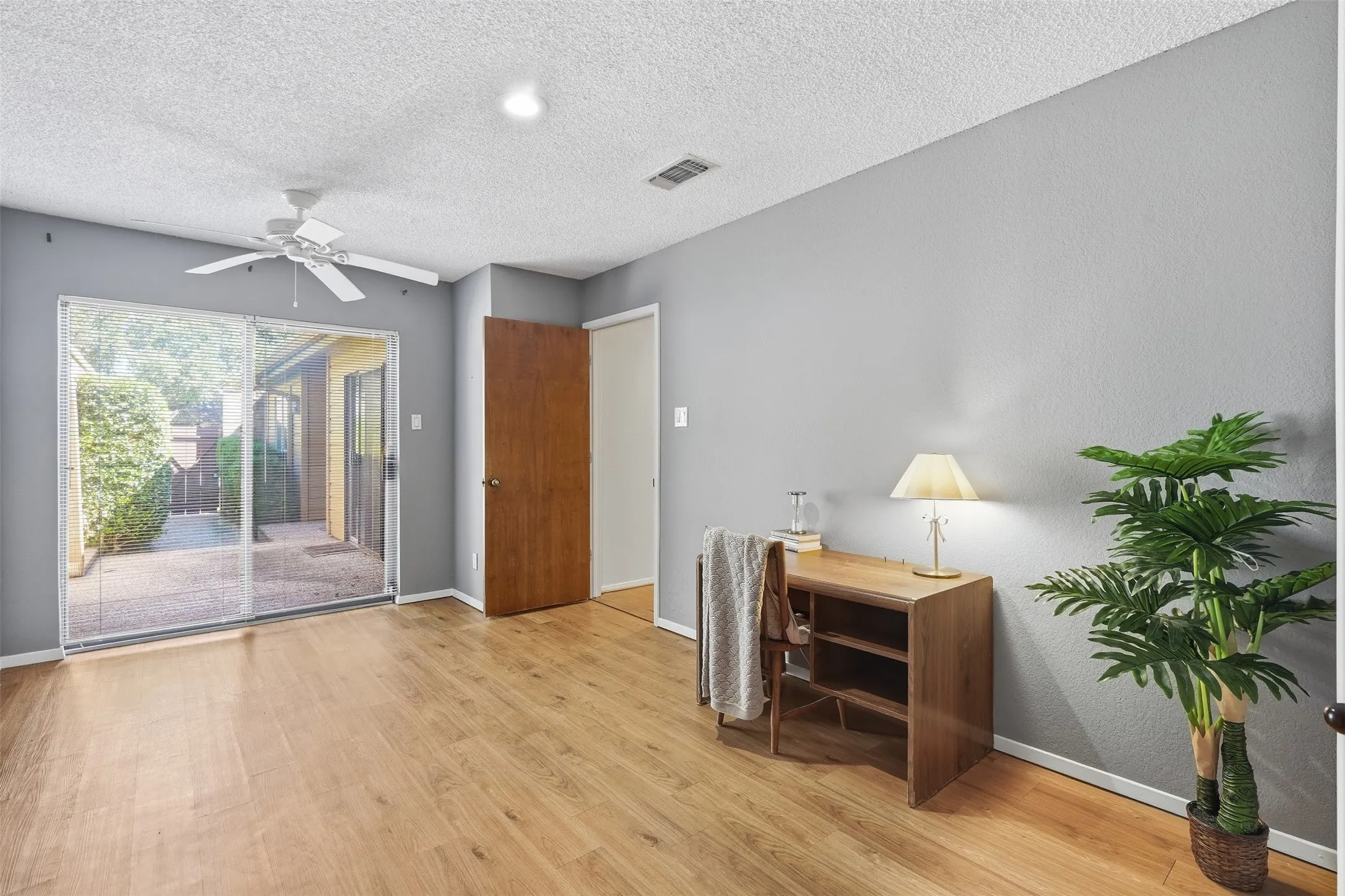 Wood-finish flooring, sliding glass patio door, ceiling fan, recessed lighting, and solid core interior door