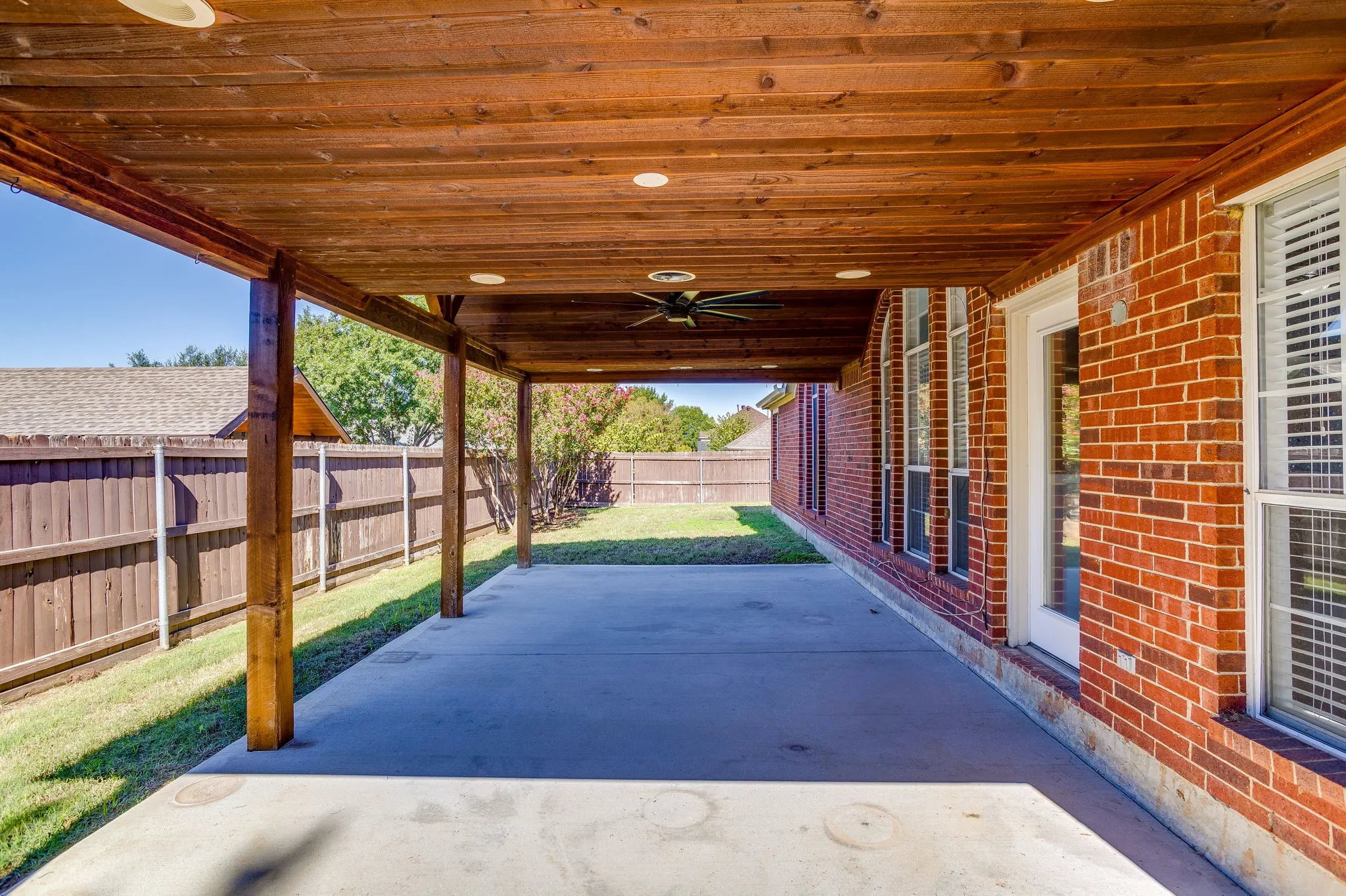 Expansive covered patio featuring a wood-finish ceiling, recessed lighting, and a ceiling fan