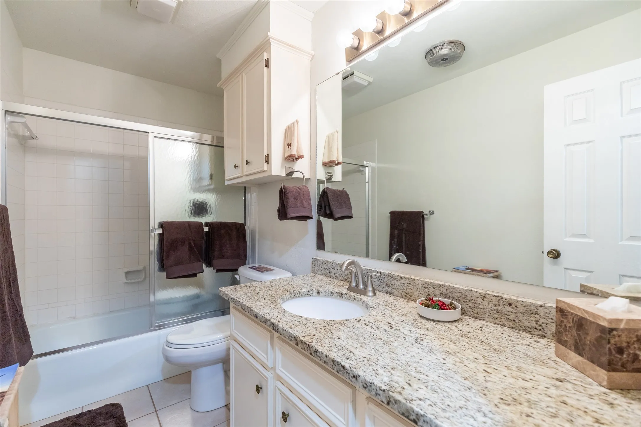 Bathroom featuring a full vanity with an integrated sink, polished chrome faucet, and a stone countertop