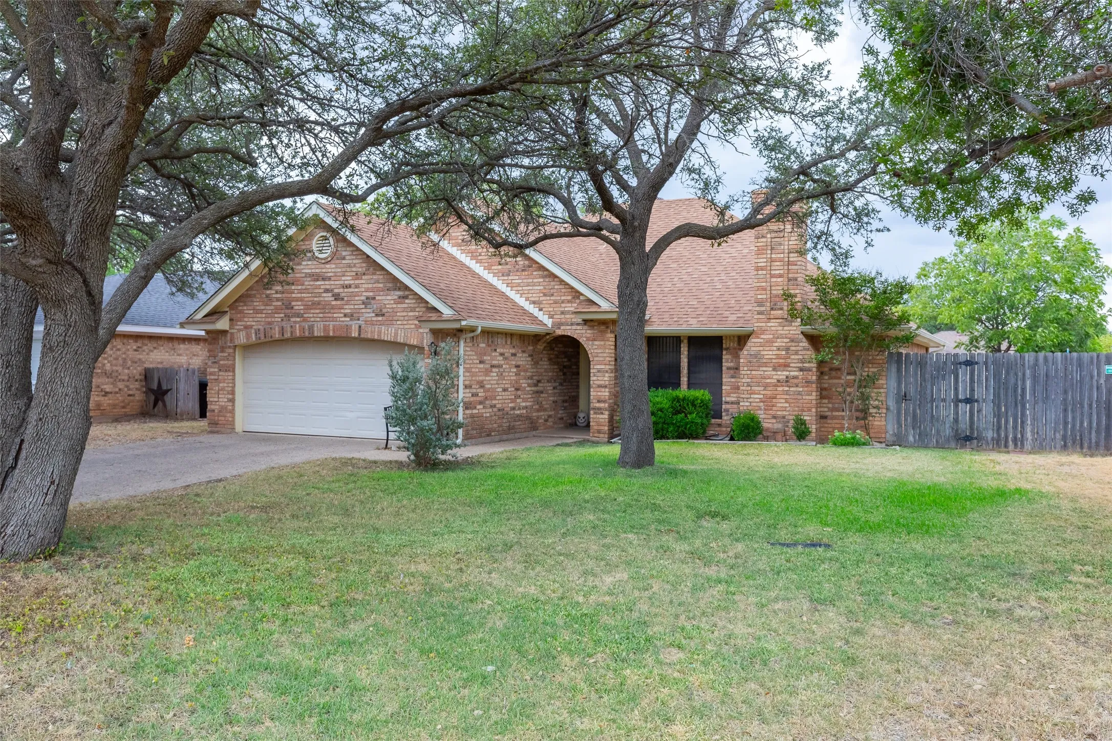 Brick exterior with an arched entry, attached garage, and pitched roofline
