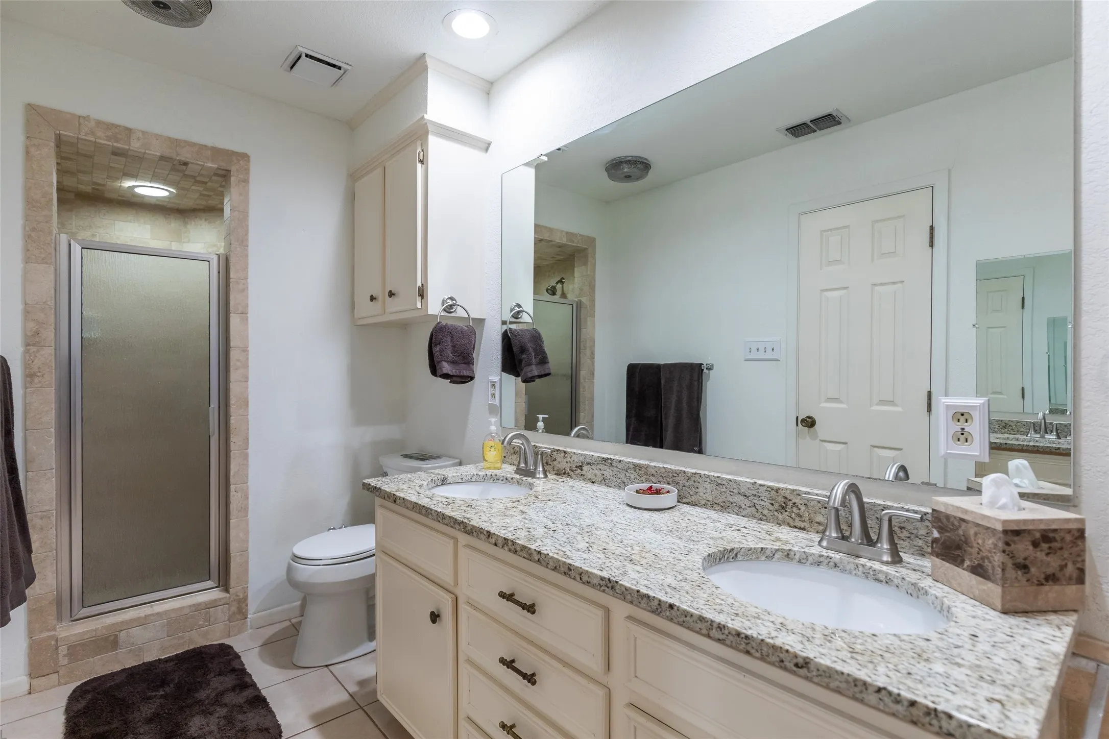 Dual vanity with granite countertop, undermount sinks, and brushed nickel fixtures