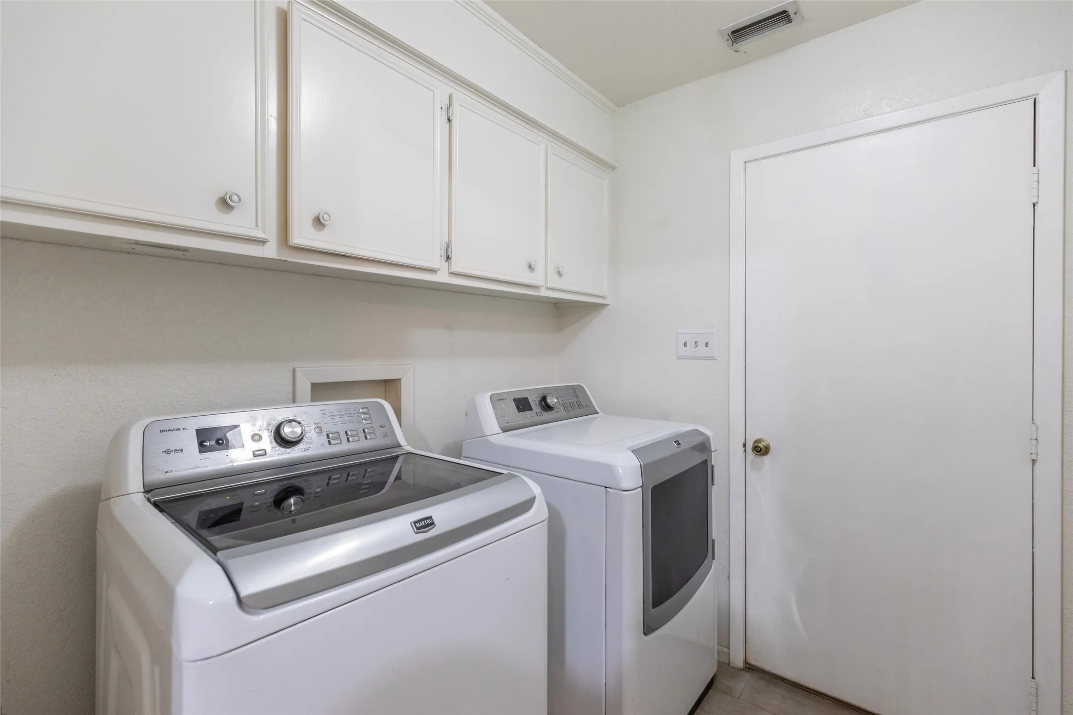 White overhead cabinetry with decorative hardware