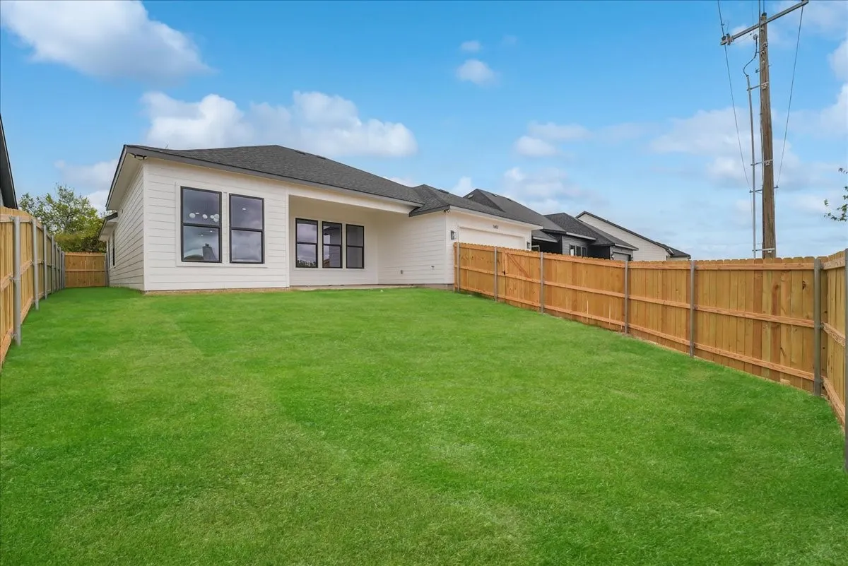 Expansive green lawn with a wood privacy fence