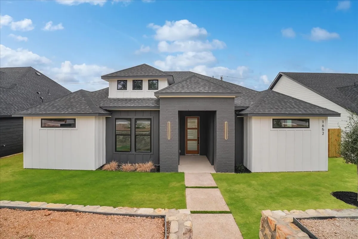 Modern exterior with dark gray brick and white board and batten siding