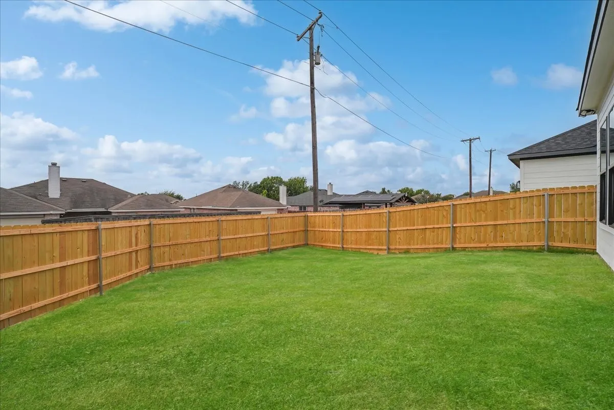 Expansive grassy yard with a wooden privacy fence