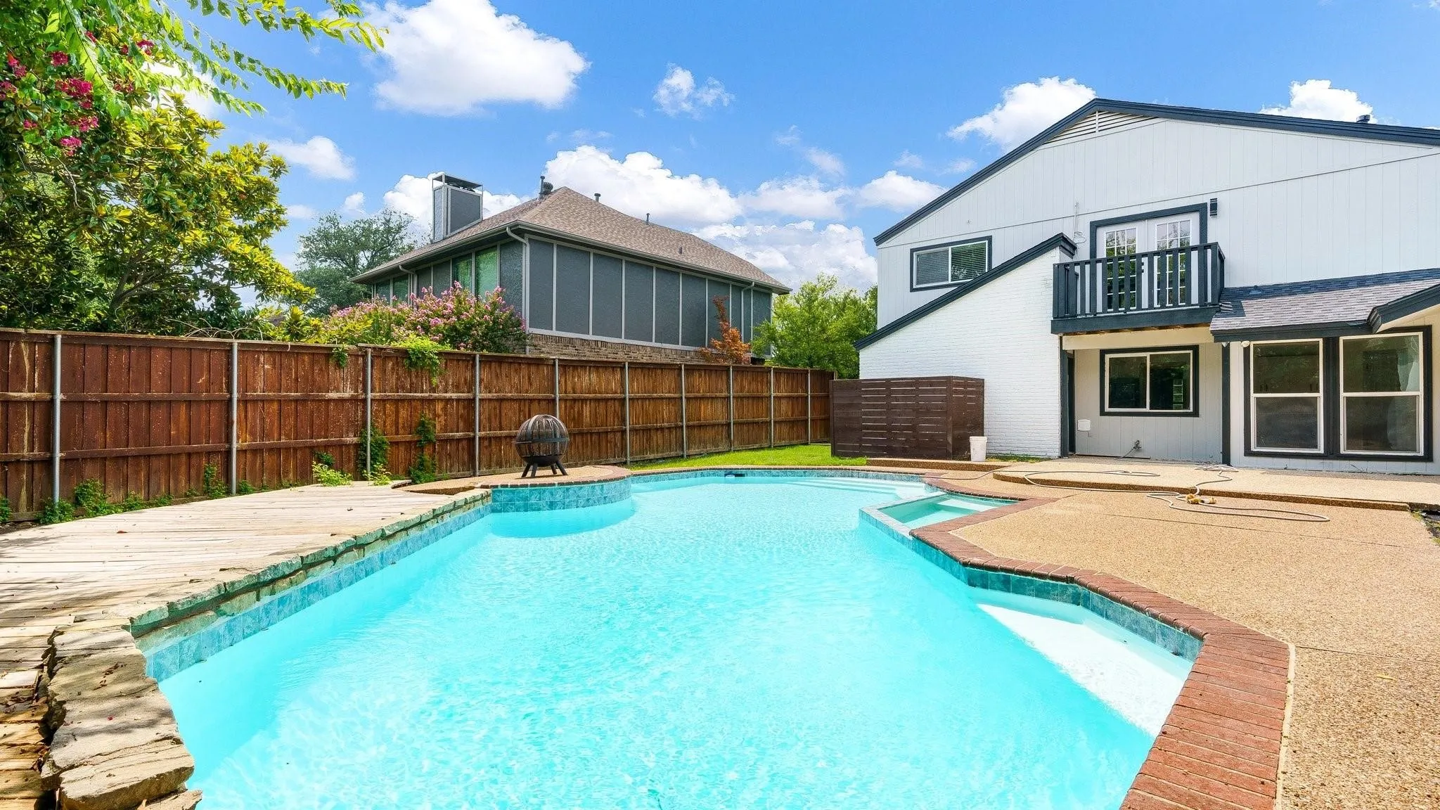 Outdoor pool with integrated spa and stone coping