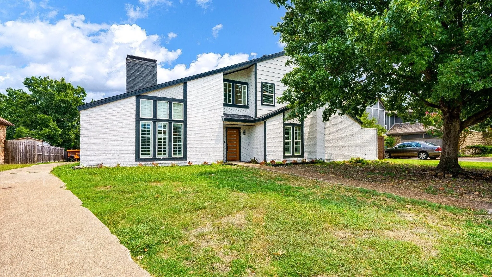 Contemporary exterior featuring white brick and dark trim