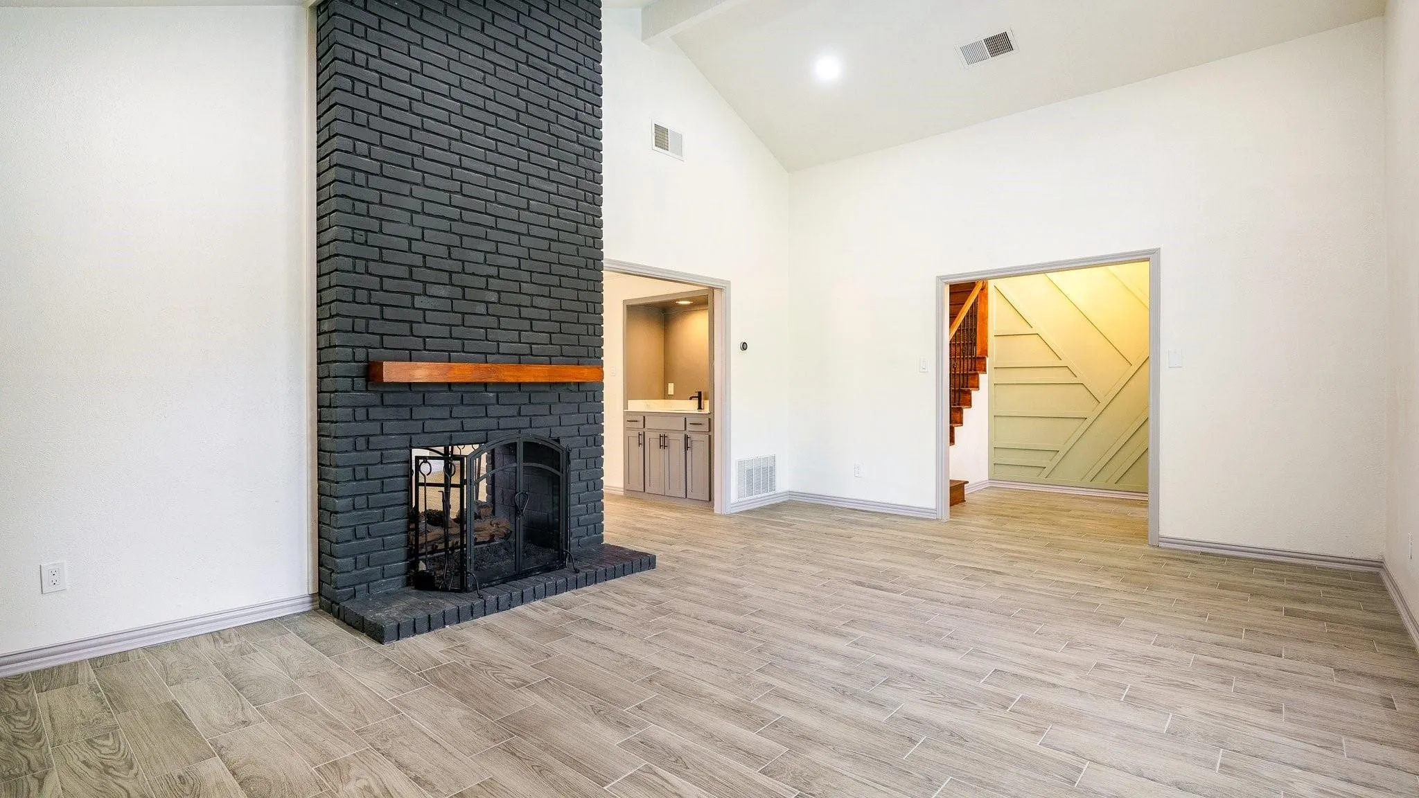 Vaulted ceilings complement the brick fireplace with wood mantel