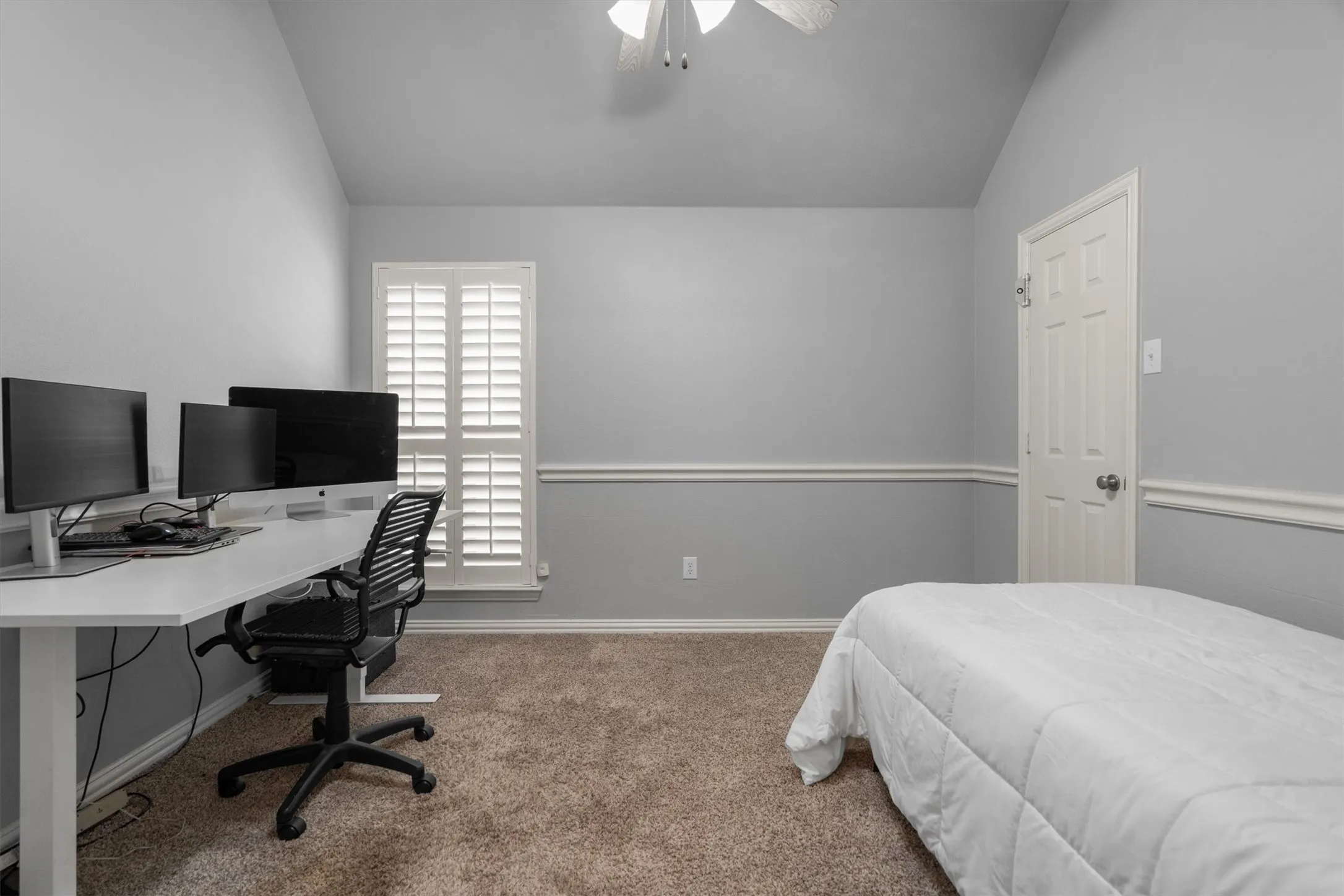 Vaulted ceiling with a ceiling fan, carpet flooring, a window with plantation shutters, and decorative wall molding