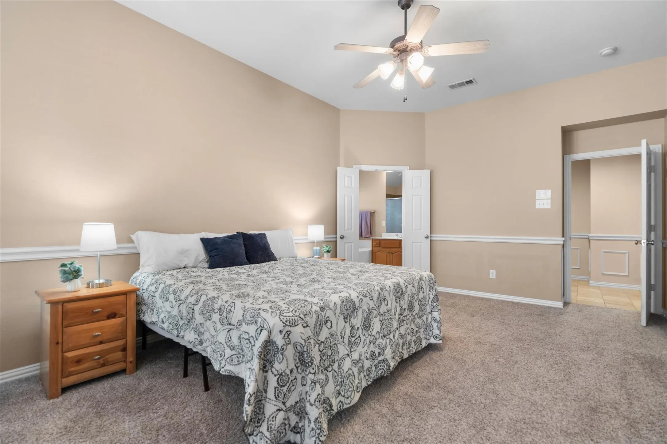 Spacious room featuring vaulted ceilings, ceiling fan with integrated lighting, soft neutral wall tones, and crown molding accents