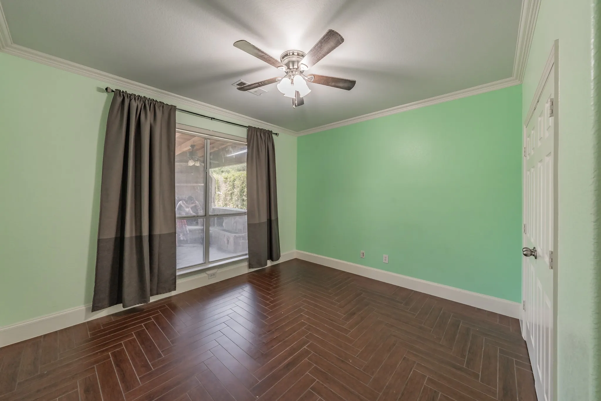 Bedroom on first floor features crown molding and ceiling fan.