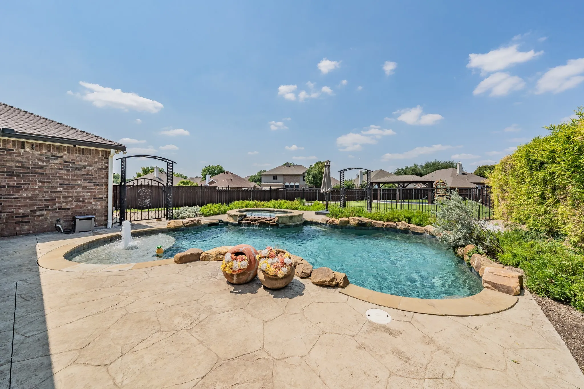 View of swimming pool with a pool with connected hot tub, a patio, and a fenced backyard