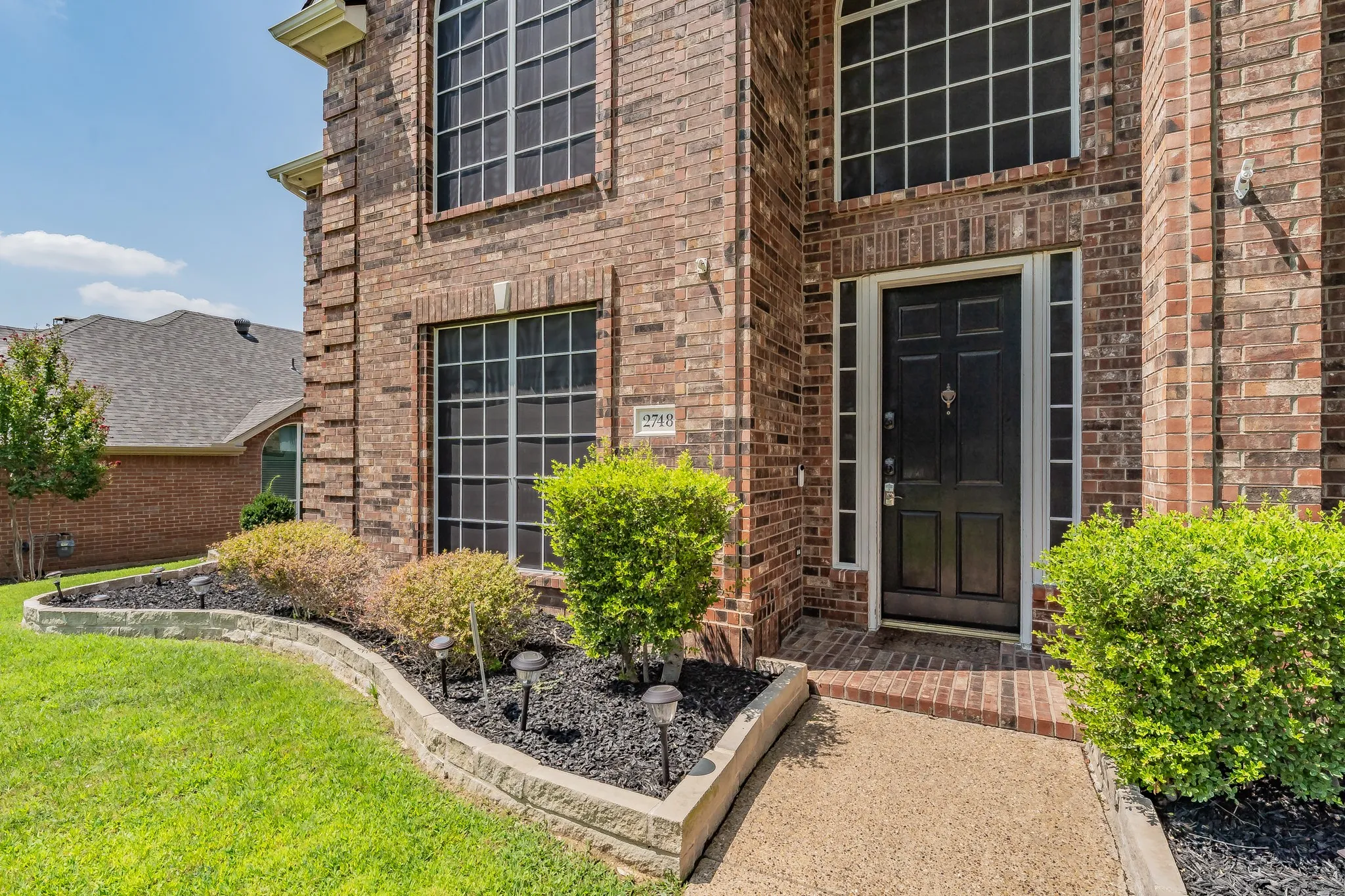 Brick exterior with decorative window trim and a dark-paneled front door