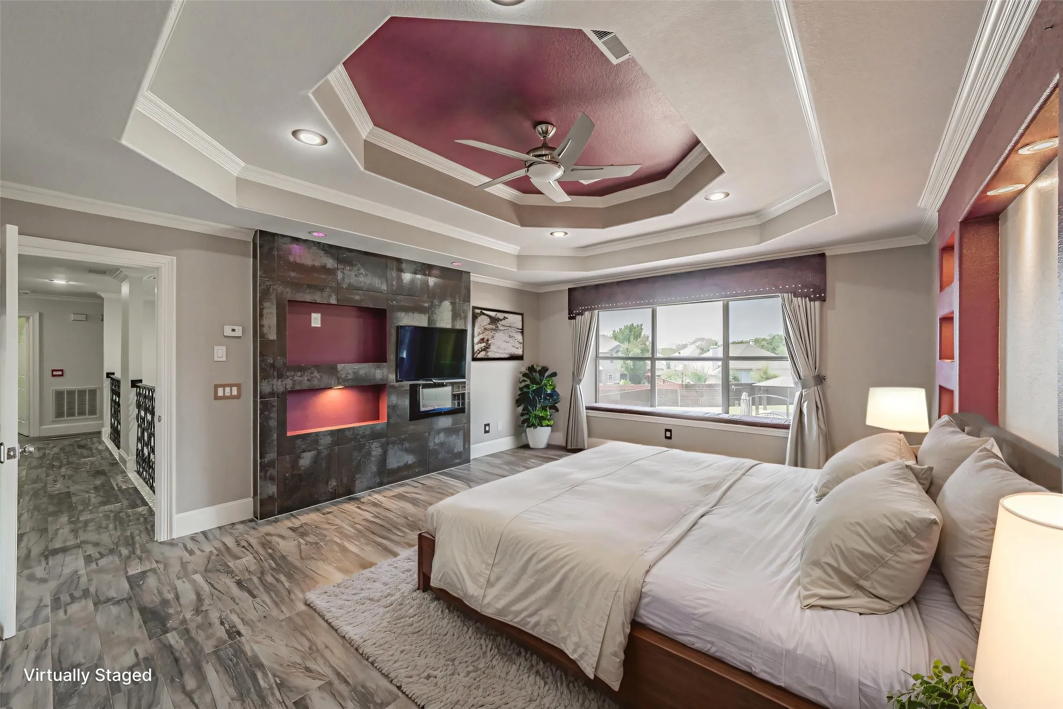 Virtually staged primary bedroom on second floor features built in fireplace.