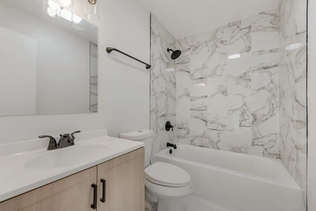 Bathroom featuring a single vanity with wood-finish cabinetry, a white countertop, and a rectangular sink