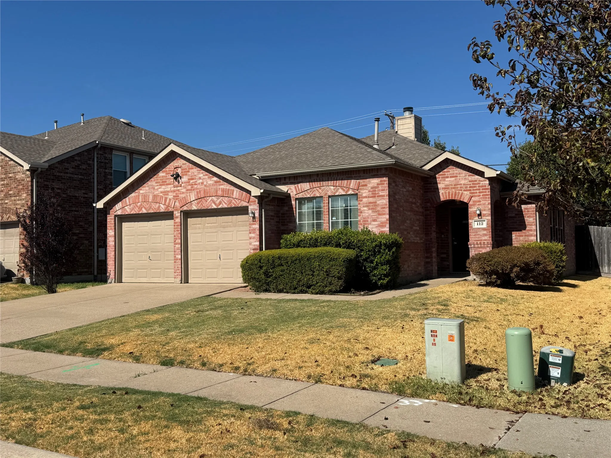 Red brick exterior with a two-car garage and arched garage door surrounds