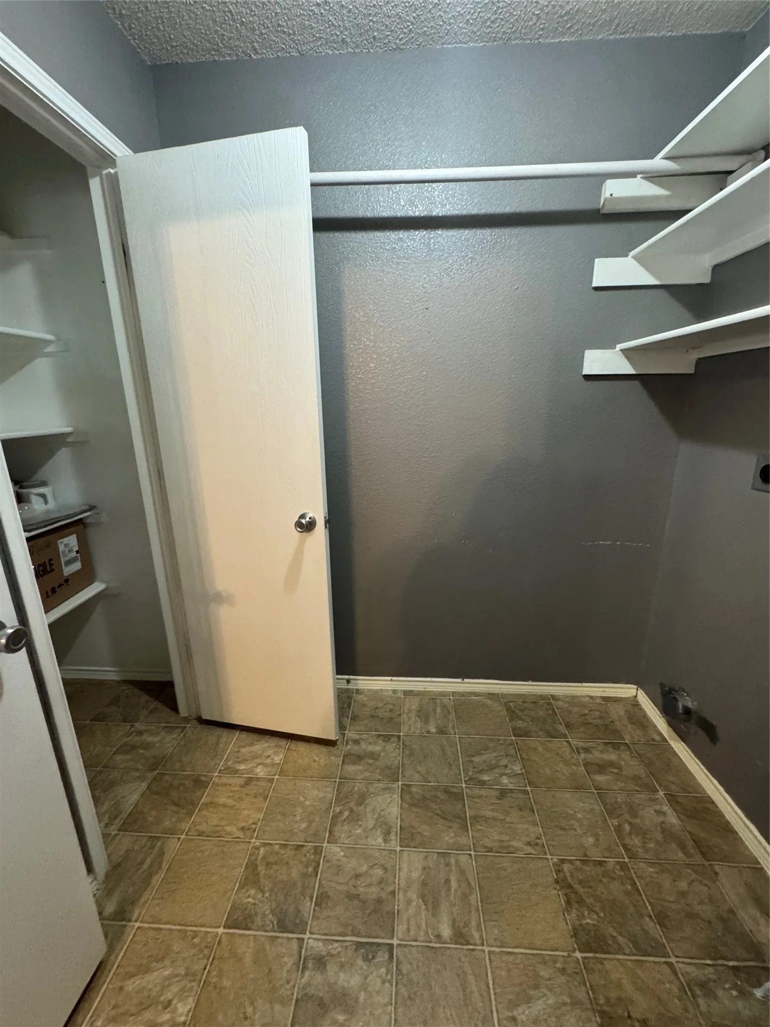 Tile flooring, built-in shelving, and a hanging rod