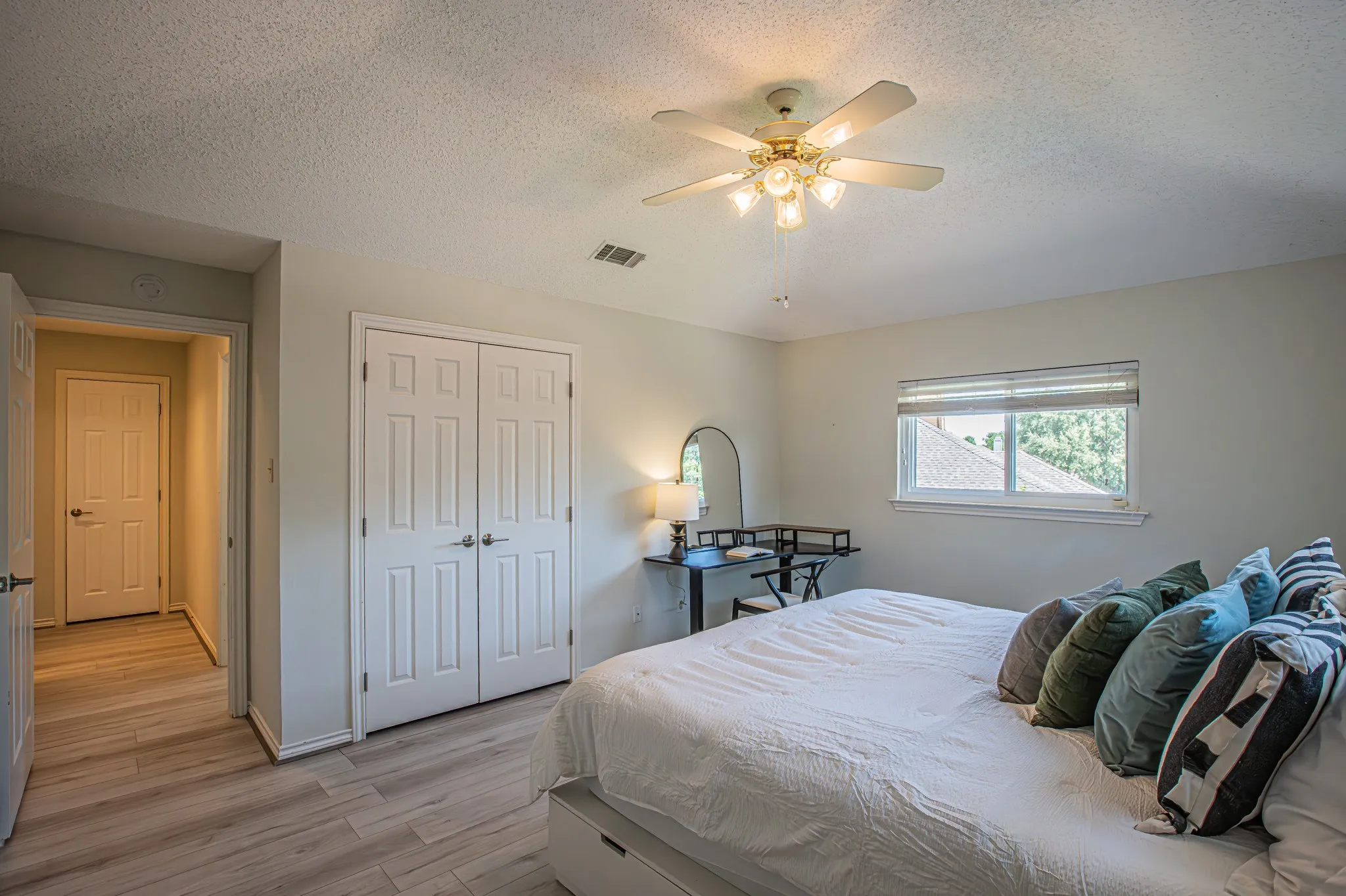 Recessed window with blinds, wood-finish flooring, white bi-fold closet doors, ceiling fan with integrated lighting, and a white ceiling