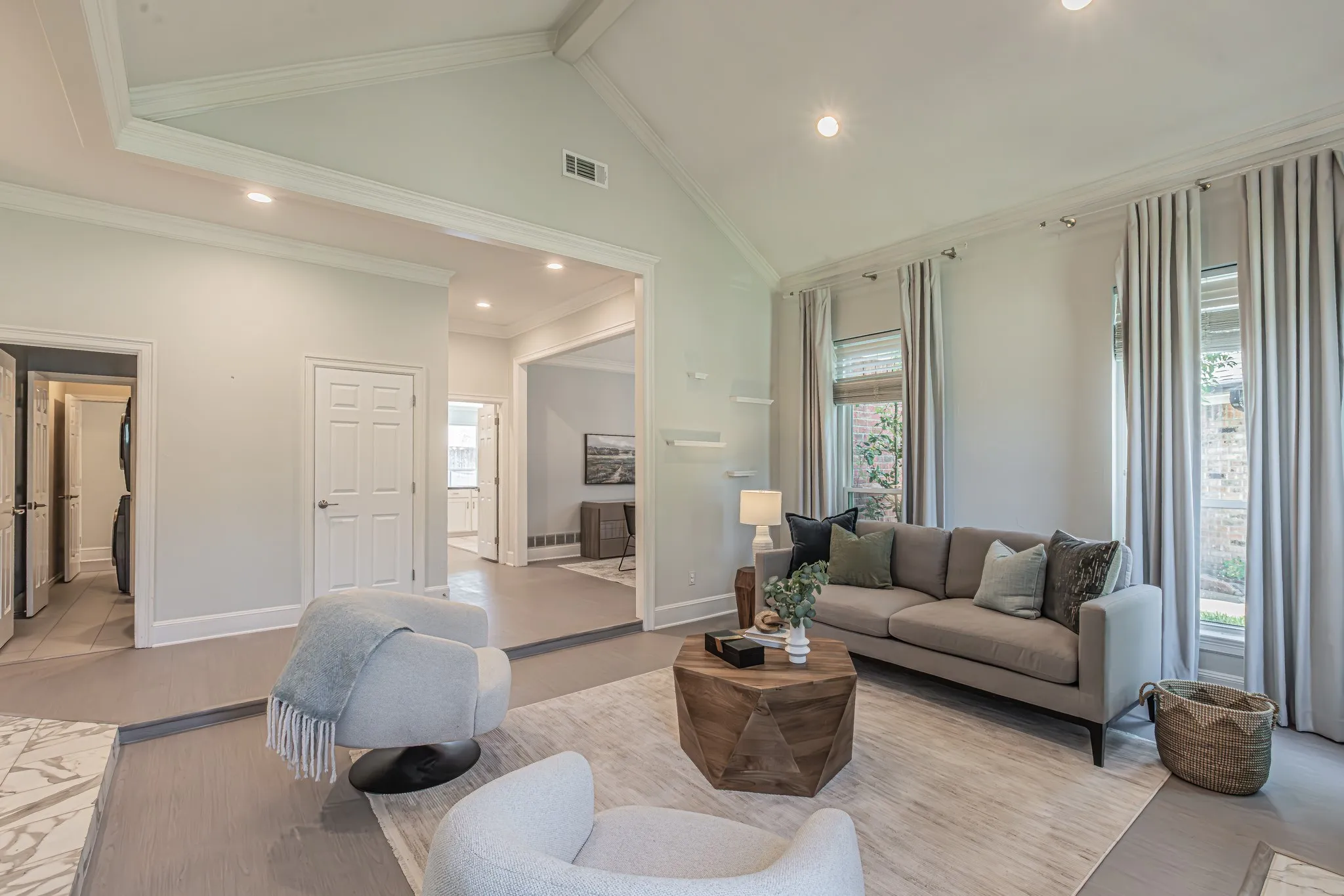 Vaulted ceiling, recessed lighting, large windows, wood-finish flooring, and a laundry area