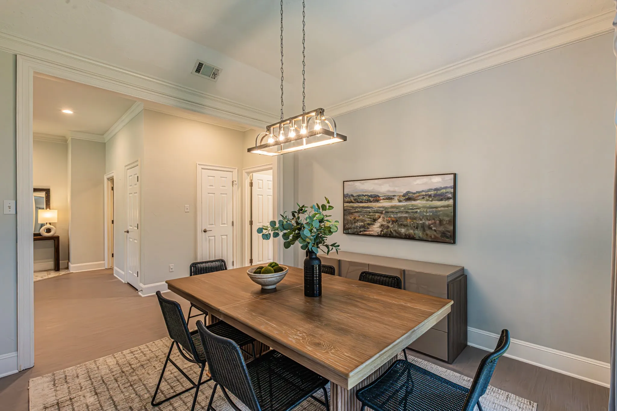 Crown molding and recessed lighting throughout, wood-finish flooring, and a contemporary linear chandelier with exposed bulbs