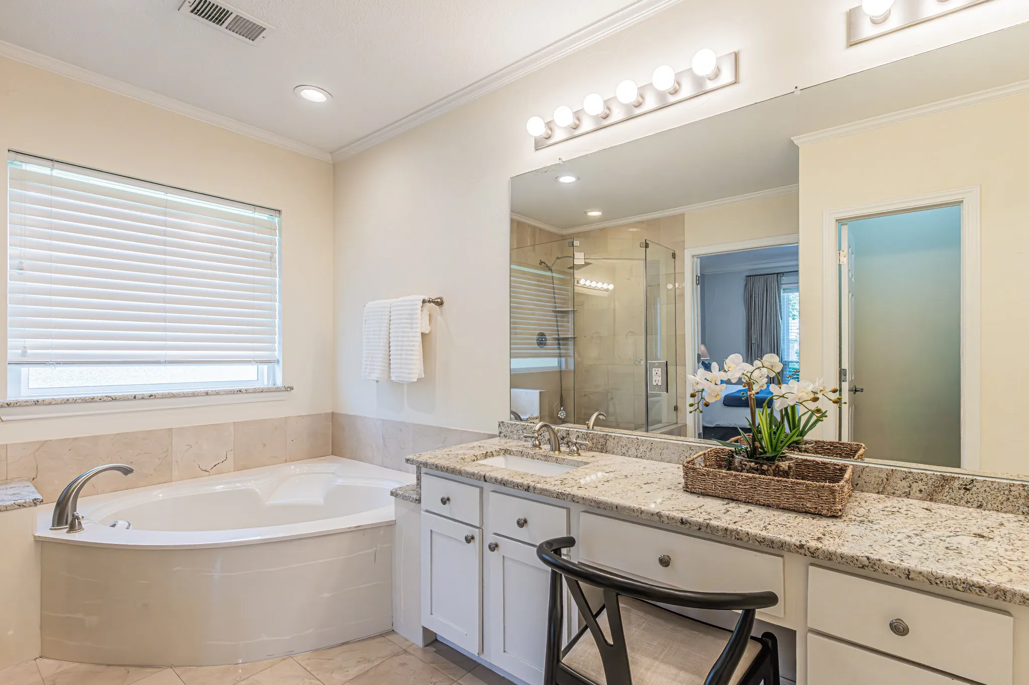 Dual vanity with granite countertops, recessed lighting, built-in soaking tub, and a glass-enclosed shower