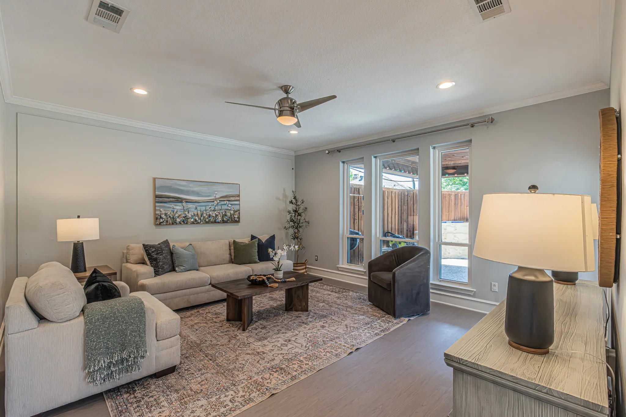 Recessed lighting, crown molding, ceiling fan, wood-finish flooring, and multiple large windows
